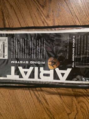 Ariat Black Riding Chaps Packaging with White Logo and Gold Accent.Genuine Ariat